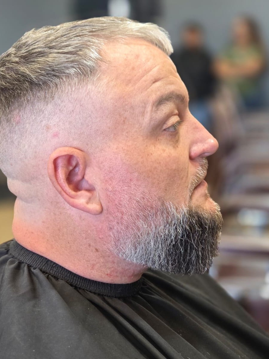 Side view of a fade haircut with a shaped beard